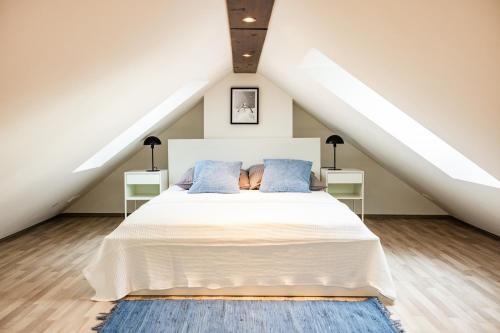 ein Schlafzimmer mit einem weißen Bett mit blauen Kissen in der Unterkunft Exklusive Apartments in Kieler City in Kiel