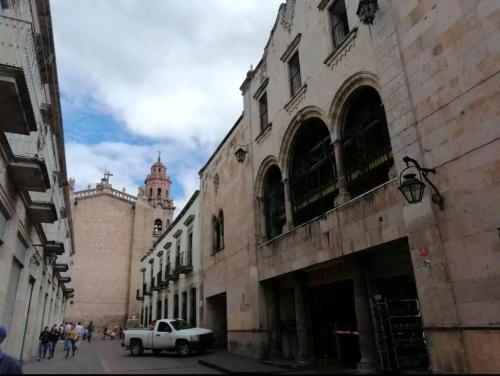 a white truck parked on a street next to a building at Estancia Real in Morelia