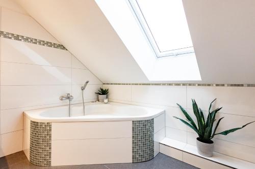 ein Badezimmer mit einem Waschbecken und einem Dachfenster in der Unterkunft Exklusive Apartments in Kieler City in Kiel