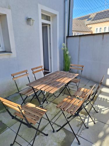 a wooden table and chairs on a patio at Flataid Apartments Ludersdorf - voll ausgestattet mit Parkplatz in Ludersdorf
