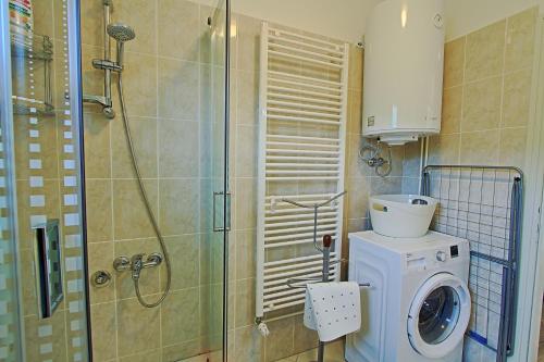 a bathroom with a washing machine and a shower at Holiday Home Sinac in Sinac