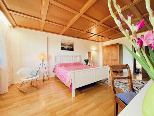 Un dormitorio con una cama y una mesa con un jarrón de flores en Haus Bergblick en Rettenberg