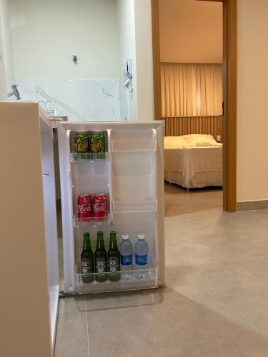 einen offenen Kühlschrank mit Wasserflaschen und Soda in der Unterkunft Loft Solaris Apart Hotel - Suíte - Apt. N.105 in João Câmara