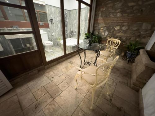 a table and chairs in a room with a bathroom at Suite Comares in Granada