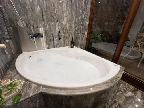 a white tub in a bathroom with a shower at Suite Comares in Granada