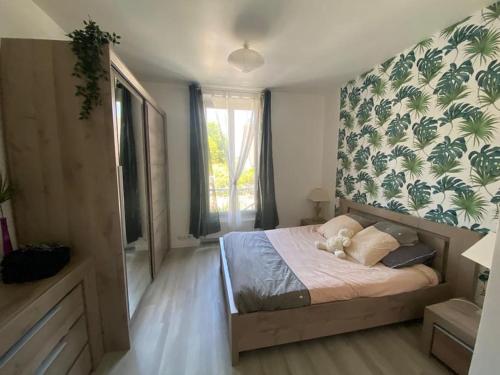 - une chambre avec un lit dans une pièce avec un mur dans l'établissement Maison lumineuse avec jardin, proche Paris Disney et Paris, à Lagny-sur-Marne