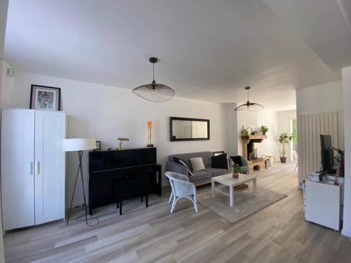 - un salon avec un canapé et un piano dans l'établissement Maison lumineuse avec jardin, proche Paris Disney et Paris, à Lagny-sur-Marne