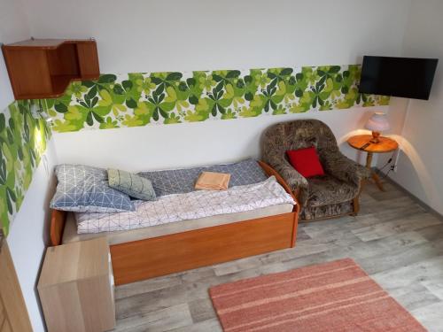 Cette petite chambre comprend un lit et une chaise. dans l'établissement Twój Dom, à Mrągowo