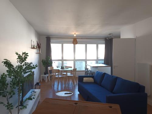 ein Wohnzimmer mit einem blauen Sofa und einem Tisch in der Unterkunft citybreak des balcons d'Ancenis in Ancenis