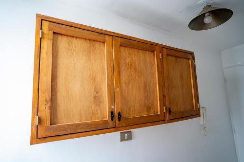 a pair of wooden cabinets hanging on a wall at Lindisimo departamento cerca del Parque O'higgins in Santiago