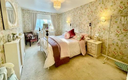 Un dormitorio con una cama con almohadas rosas. en Mulberry Annexe en Felixstowe