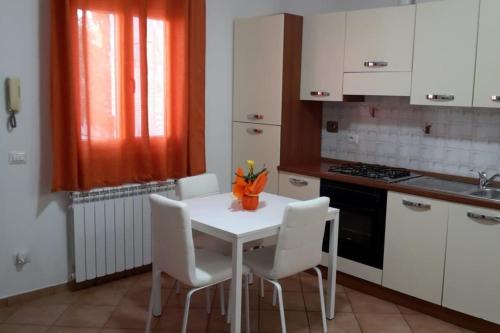 a kitchen with a white table and white chairs at Casa di Cristina in Fiumicino