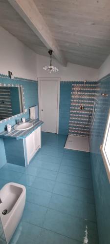 uma casa de banho azul com um lavatório e um WC em Costa Smeralda Villetta indipendente vista mare em Porto Cervo