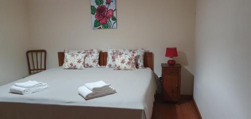 アルヴァドスにあるCasa dos Imosのベッドルーム1室(白いベッド1台、タオル付)