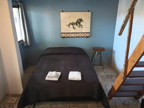 Cama en habitación azul con 2 toallas en Lovely studio with stunning terrace, en Tigre