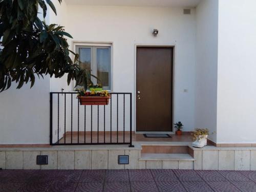 a building with a porch with a door and a plant at Casa di Cristina in Fiumicino