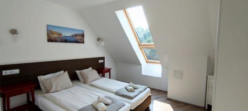 um pequeno quarto com uma cama e uma janela em FreshGarden Family Resort em Siófok