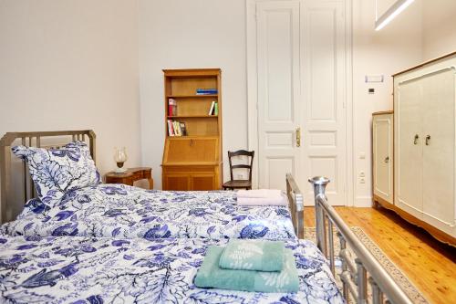 a bedroom with a bed with a blue and white comforter at 1906 Citygarden in Chios