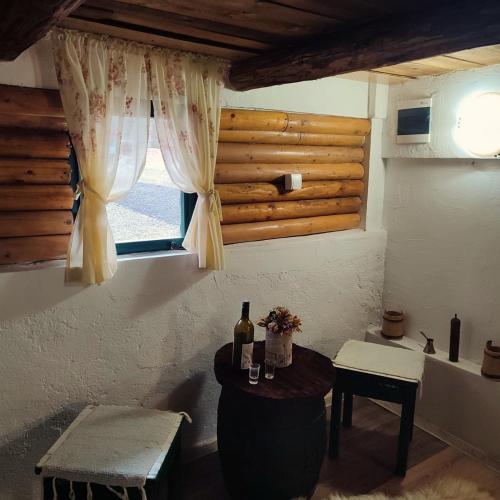 um quarto com uma janela e uma mesa com garrafas de vinho em Brvnara Gromki - Mountain house em Han Pijesak