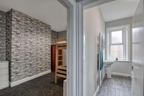 a bathroom with a brick wall and a sink at Colston 5 Bedroom House Newcastle in Newcastle upon Tyne