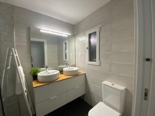 a bathroom with two sinks and a toilet at APARTAMENTO RECONQUISTA in Toledo