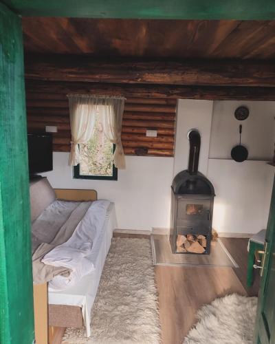 uma sala de estar com um sofá e uma lareira em Brvnara Gromki - Mountain house em Han Pijesak