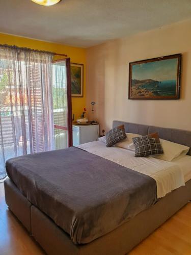 a large bed in a bedroom with a large window at Animari Apartments in Stari Grad