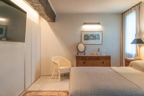 - une chambre avec un lit, une commode et un miroir dans l'établissement Casale Gambini, à Quattro Castella
