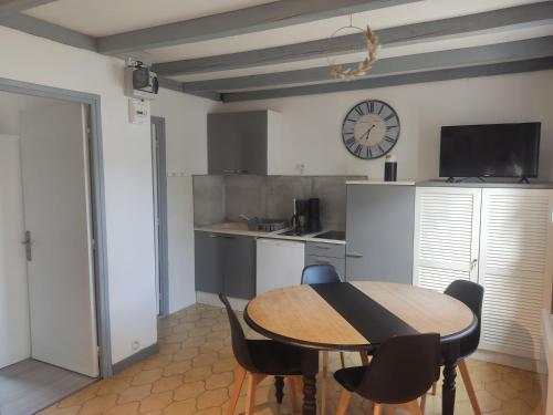 une cuisine avec une table, des chaises et une horloge dans l'établissement Maisonnette, à Carpentras