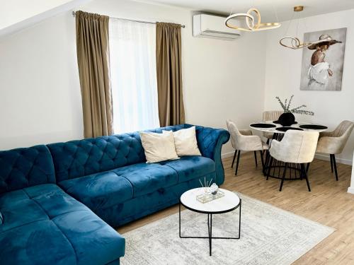 a living room with a blue couch and a table at Apartman Star #2 in Vinkovci