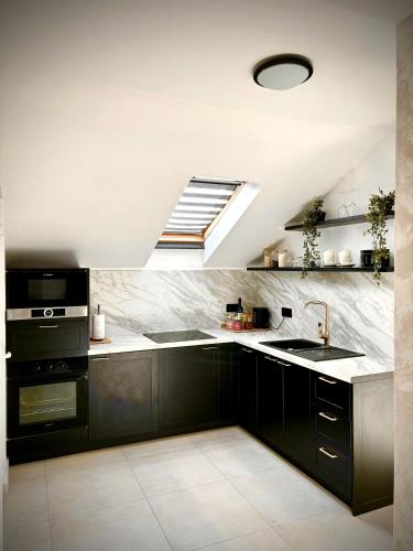 a kitchen with black cabinets and a sink at Apartman Star #2 in Vinkovci
