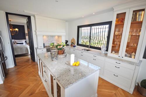 eine Küche mit weißen Schränken und einer Arbeitsplatte in der Unterkunft Riviera Living in Mandelieu-la-Napoule