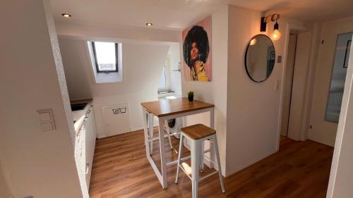 a small kitchen with a table and a mirror at 3 Zimmer Apartment mit Parkplatz - Sleepomat in Aschaffenburg