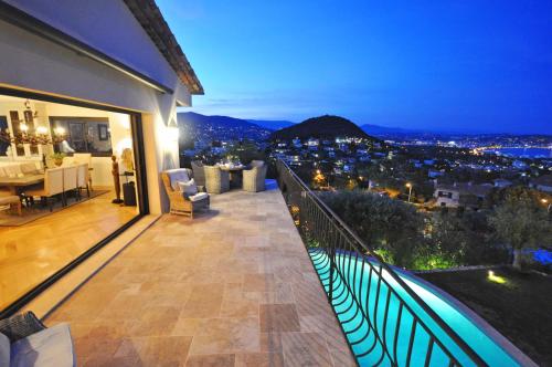 a balcony with a view of a city at night at Riviera Living in Mandelieu-la-Napoule
