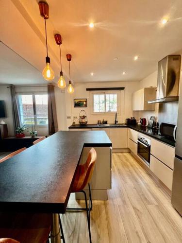 - une cuisine avec un grand comptoir noir dans la chambre dans l'établissement Villa Mia*, à Toulon