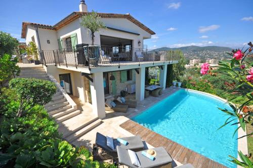 a villa with a swimming pool and a house at Riviera Living in Mandelieu-la-Napoule