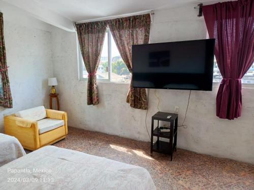 a living room with a flat screen tv on the wall at Posada Familiar Papantla in Papantla de Olarte
