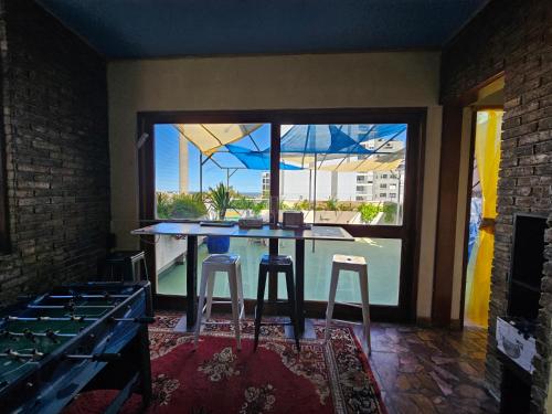 uma cozinha com uma mesa com bancos e uma grande janela em Montevideo Hostel em Montevidéu