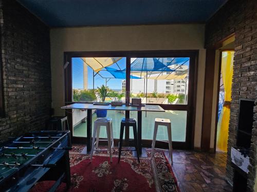 a kitchen with a table with stools and a large window at Montevideo Hostel in Montevideo