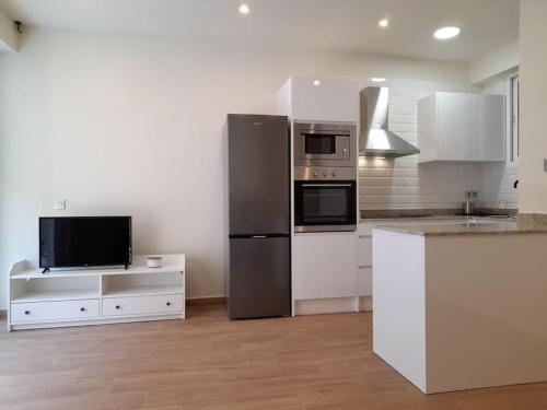 a kitchen with a stainless steel refrigerator and a tv at Apartamento Playa Paseo Marítimo Almería in Almería