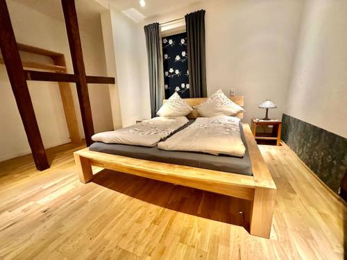 um quarto com uma cama de madeira com almofadas em Wohnung in Weilburg am Schloss em Weilburg