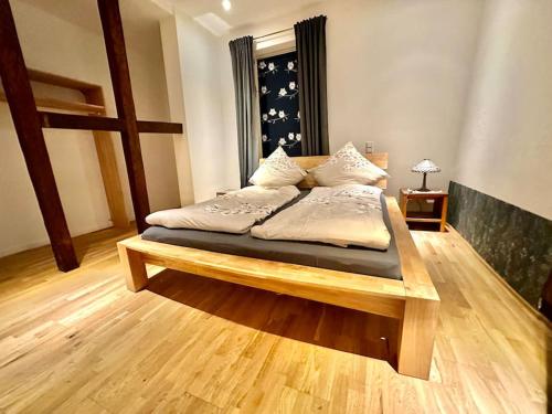 a bedroom with a wooden bed with pillows on it at Wohnung am Schloss 2 - Bestes Apartment in Weilburg in Weilburg