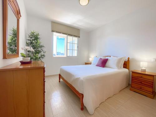 une chambre avec un grand lit blanc et une fenêtre dans l'établissement Fee4Me Casa Emilia few meters from the beach, à Lajita