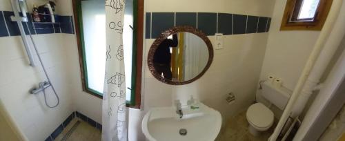a bathroom with a sink and a mirror and a toilet at Kisfaludy Apartment House in Gárdony