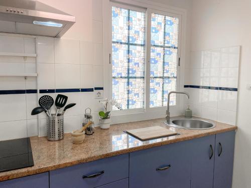 une cuisine avec un évier et une fenêtre dans l'établissement Fee4Me Casa Emilia few meters from the beach, à Lajita
