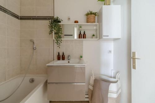 une salle de bain avec un lavabo et une baignoire dans l'établissement Beau T3 à quelques minutes des sites Olympiques, à Montigny-le-Bretonneux