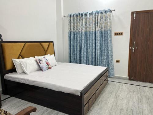 een slaapkamer met een bed met een blauw gordijn bij Shri Ram International Home Stay Ayodhya in Ayodhya