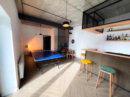 a kitchen with a ping pong table and chairs at Landscapes Hotel Kazbegi in Stepantsminda