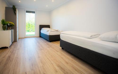 2 letti in una camera con pavimento in legno di Bellami Ferienwohnungen a Minden