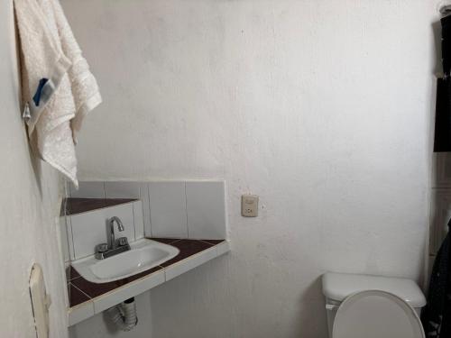 un bagno bianco con lavandino e WC di LA VILLA DE LA ABUELA a San Cristóbal de Las Casas